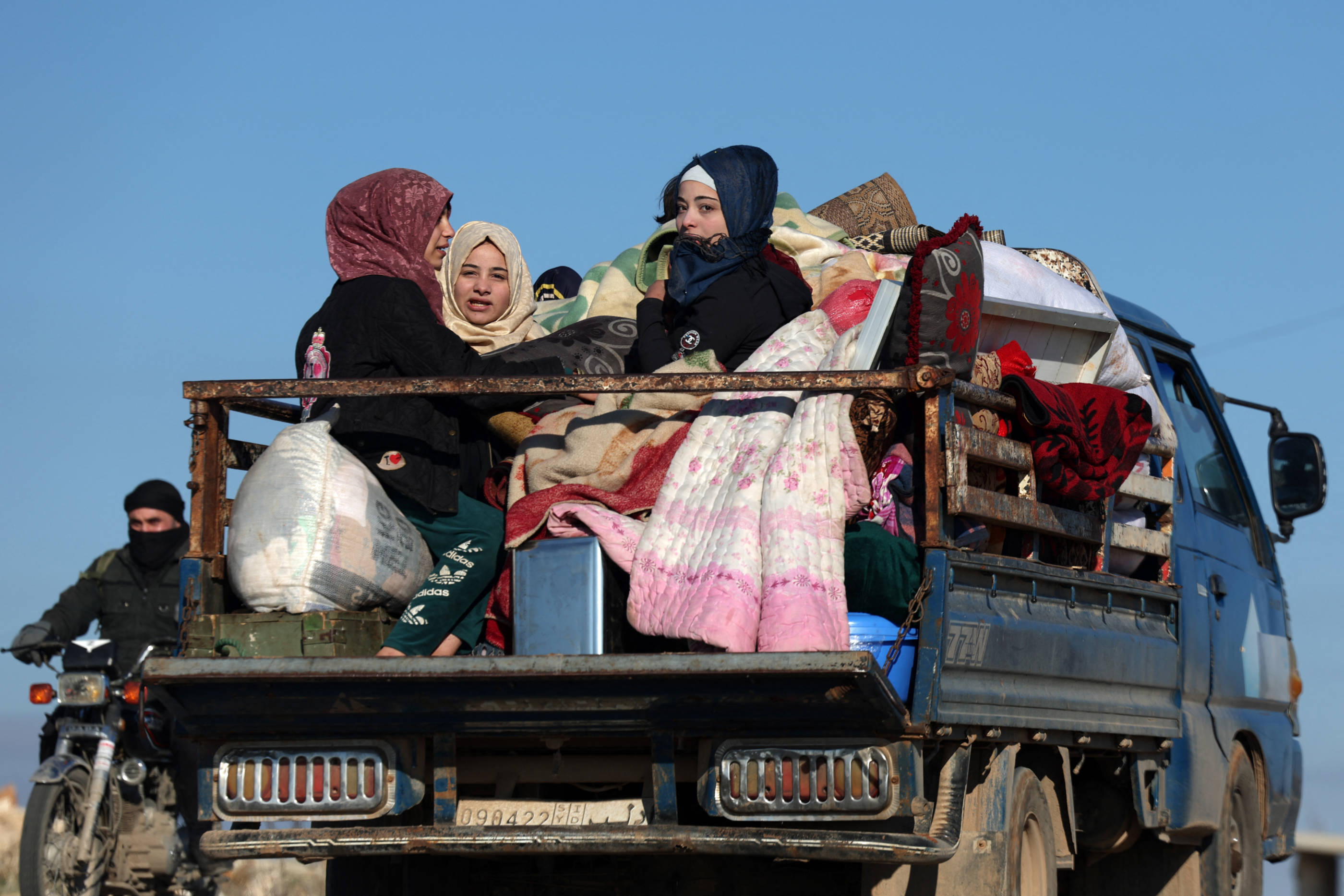 People flee the northern Ariha village during clashes between Syrian rebels and government forces on the front lines on the outskirts of the city of Saraqib, Aleppo province, on 28 November 2024 (AFP)