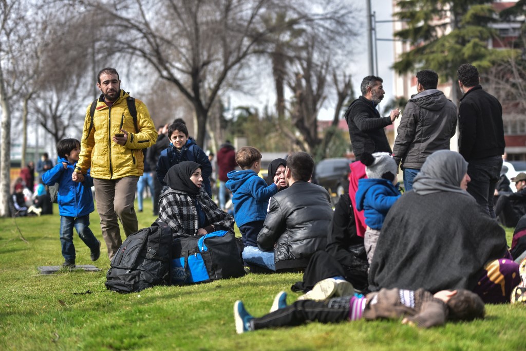 Syrian refugees wait to board a bus in Istanbul, as they head to the Turkish border, 28 February 2020 (AFP)