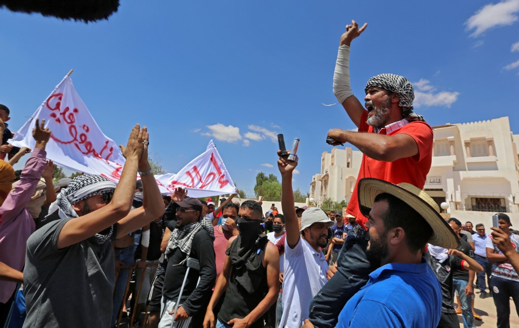 Tunisian chant slogans during a gathering, to demand the release of detained protesters who were tried for disrupting public order, in front of the local court in Tataouine on June 23, 2020. 