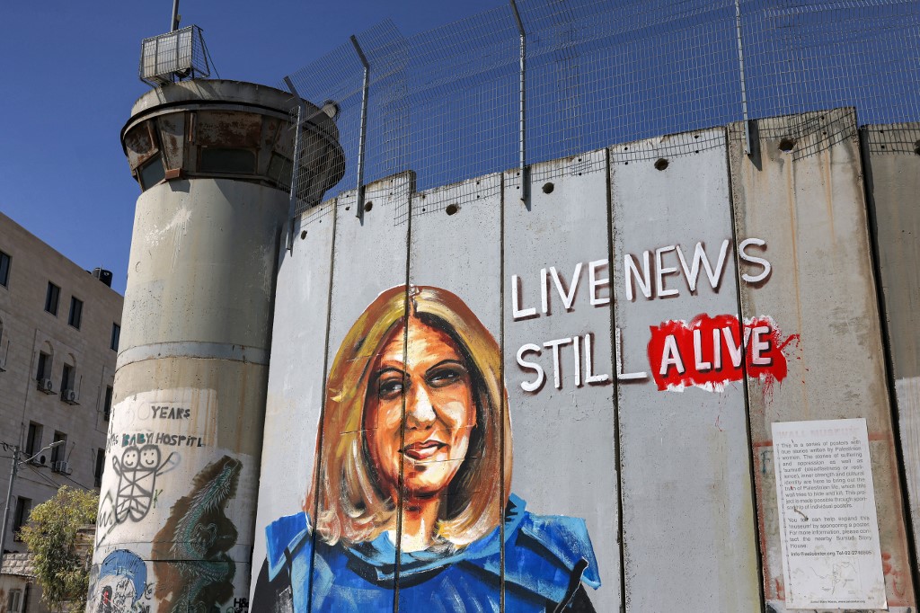 A mural depicting slain Al Jazeera journalist Shireen Abu Akleh drawn along Israel's controversial separation barrier in Bethlehem in the occupied West Bank, 6 July 2022 (AFP)