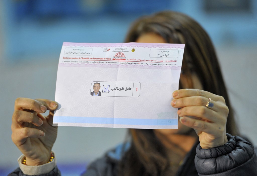 An agent of the electoral authority (ISIE) shows a ballot at a polling station in Tunis on 17 December 2022, during the parliamentary elections (Yacine Mahjoub/AFP)