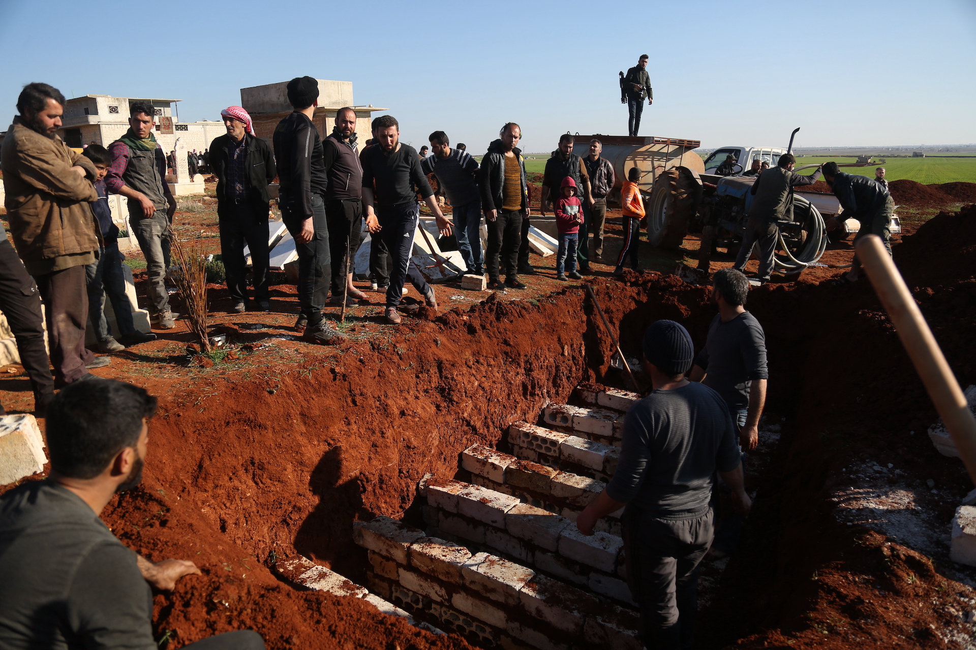 Residents of Idlib's Maaret Elnaasan lay to rest family members slain in Saturday's attack (MEE/Ali Haj Suleiman)