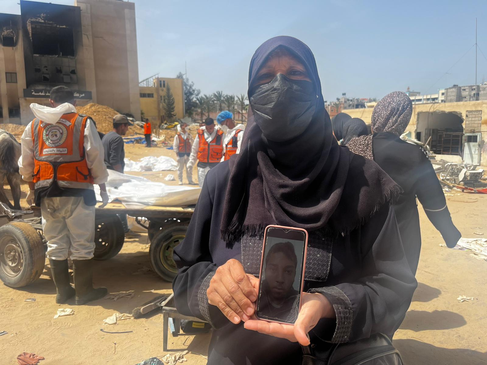 Amal al-Baiouk holds an image of her son Medhat Suleiman Aata outside Nasser hospital in Gaza's Khan Younis (MEE/Maha Hussaini)