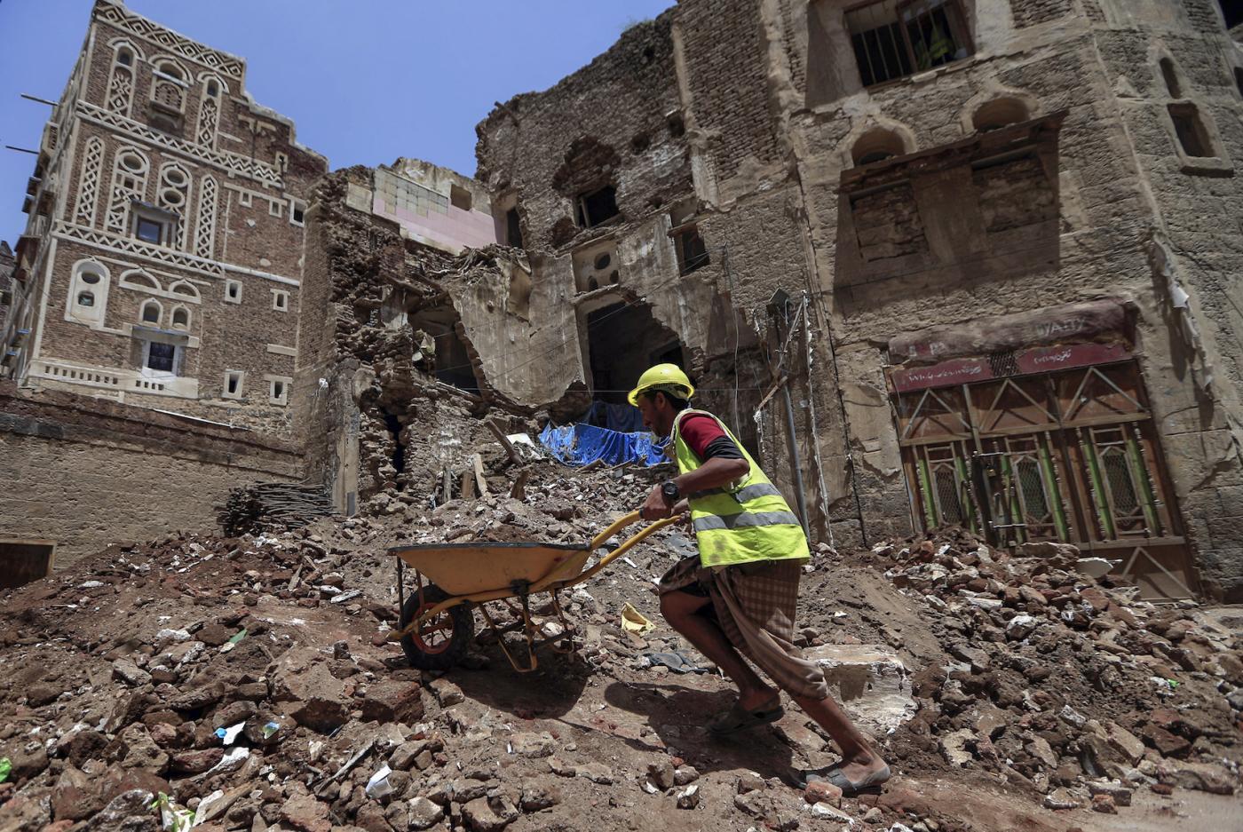 Dans la vieille ville de Sanaa, un ouvrier déblaie les décombres avant la restauration d’un bâtiment inscrit au patrimoine mondial de l’UNESCO qui s’est effondré à la suite de fortes pluies (AFP)
