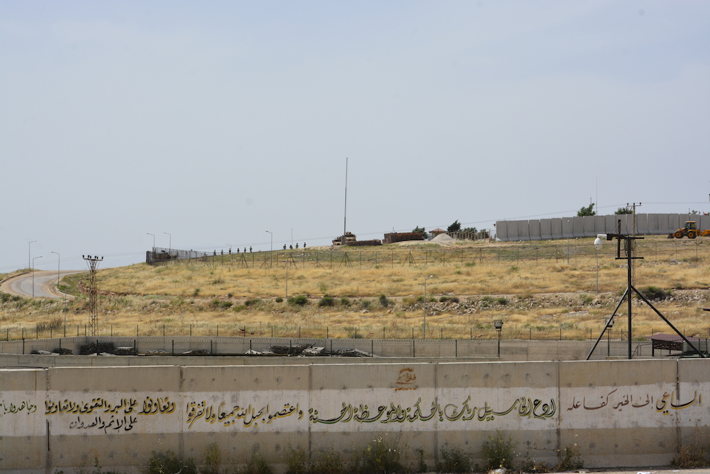 Turkish military vehicles and soldiers deployed behind the border wall, in Syrian-Turkish border in the town of Atme north of Idlib (Harun al-Aswad)