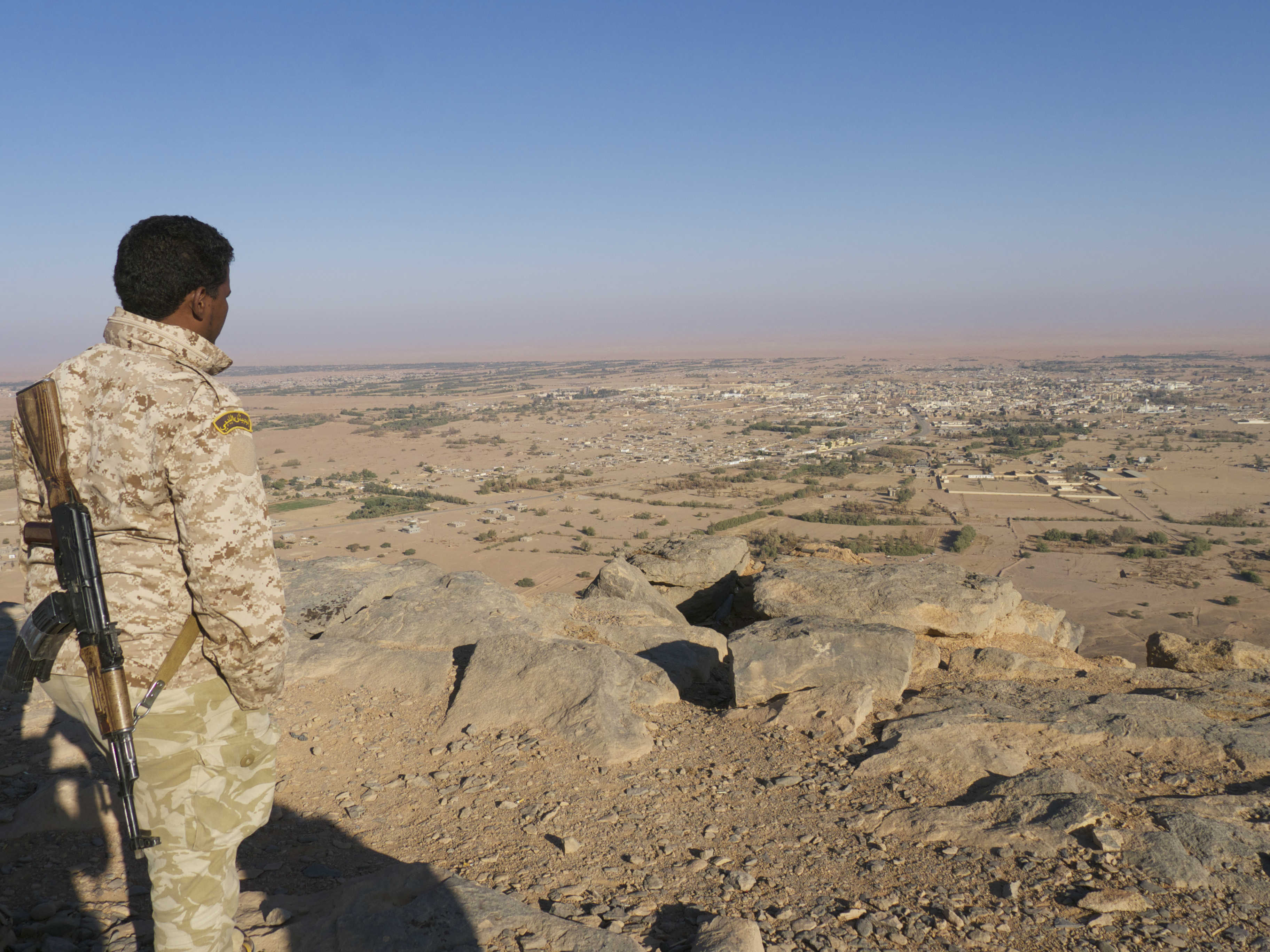 A Tuareg fighter overlooking Ubari from a mountain in 2015 (MEE/Tom Wescott)