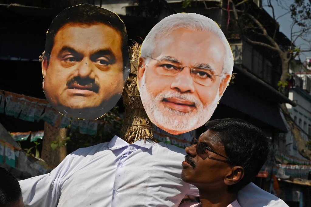 An activist of India's Congress party carries an effigy of Prime Minister Narendra Modi and Indian tycoon Gautam Adani during a rally organised to protest against the union government’s financial policies in Kolkata on February 6, 2023.