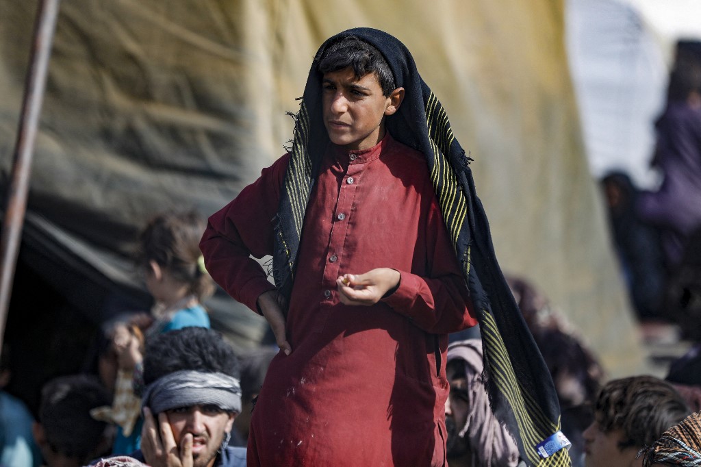 A handout picture made available by the Iranian Red Crescent on August 19, 2021, shows Afghan refugees gathered at the Iran-Afghanistan border between Afghanistan and the southeastern Iranian Sistan and Baluchestan province