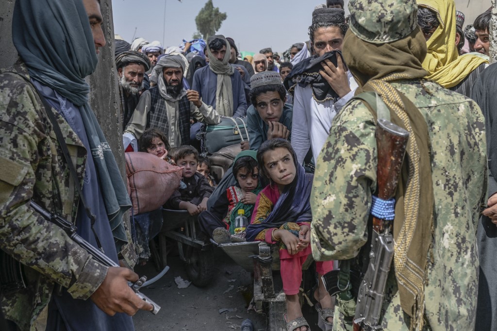 People stand as Taliban members stopped them while rushing to pass to Pakistan from the Afghanistan border in Spin Boldak on September 25, 2021. 