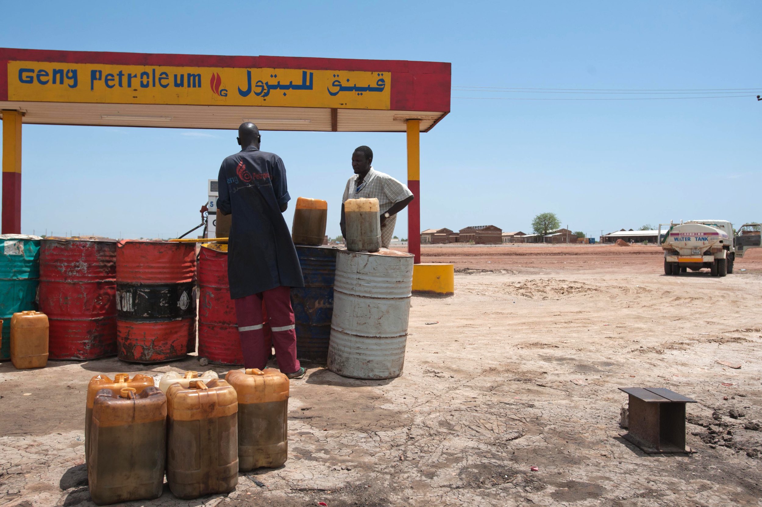 A truck driver buys a jerrycan of petrol for around 300 South Sudanese Pounds ($100) at a makeshift gas station in Bentiu, Unity State, on 23 May 2012 (AFP)