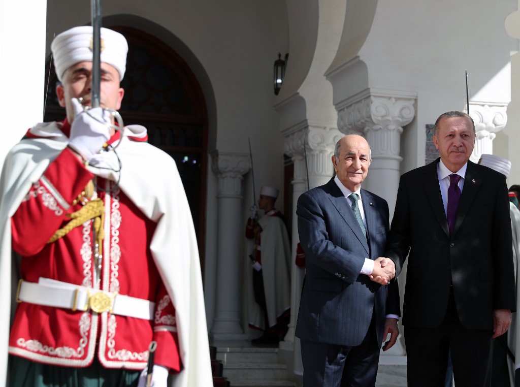 This handout picture taken and released on January 26, 2020 by the Turkish Presidential Press service shows Algerian President Abdelmadjid Tebboune (L) shaking hands with Turkish President Recep Tayyip Erdogan (R) during his arrival for a visit to Algeria