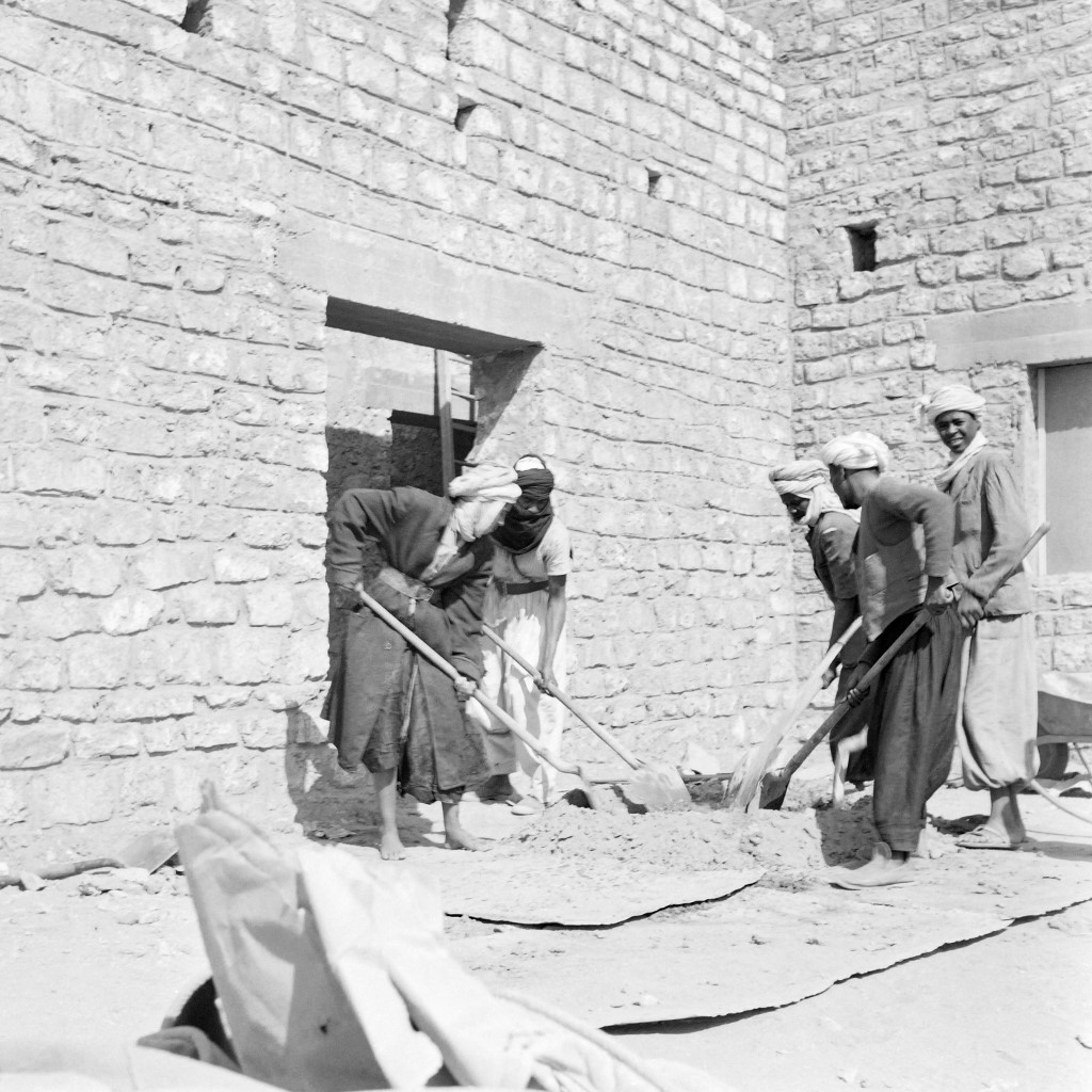 Des ouvriers travaillent à la construction d’un bâtiment à Edjeleh, à 250 km au sud d’In Salah, près de la frontière libyenne, en mars 1957 (AFP)