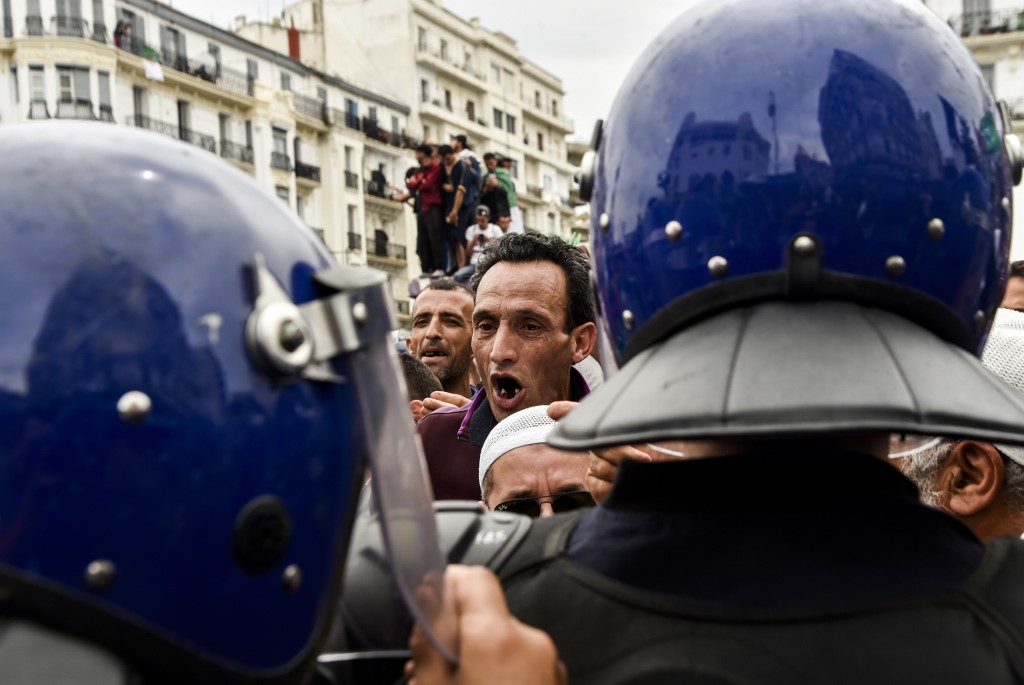 Algerian riot police stand on guard as anti-government protesters gather in Algiers on 24 May (AFP)