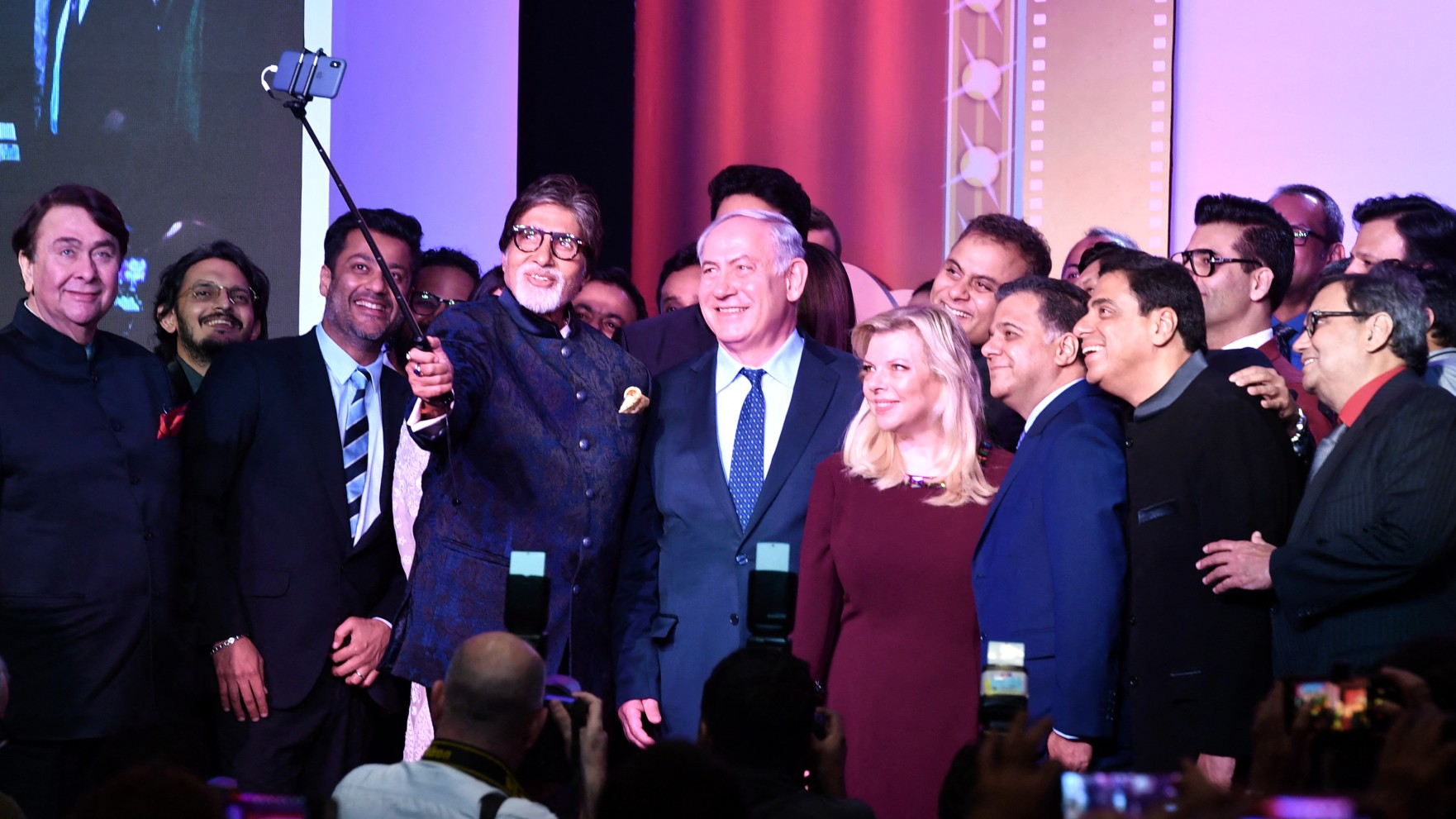 Indian Bollywood actor Amitabh Bachchantakes a selfie picture with a selfie stick with Israel Prime Minister Benjamin Netanyahu (C), his wife Sara and other guests at the Shalom Bollywood event in Mumbai on January 18, 2018. INDRANIL MUKHERJEE / AFP