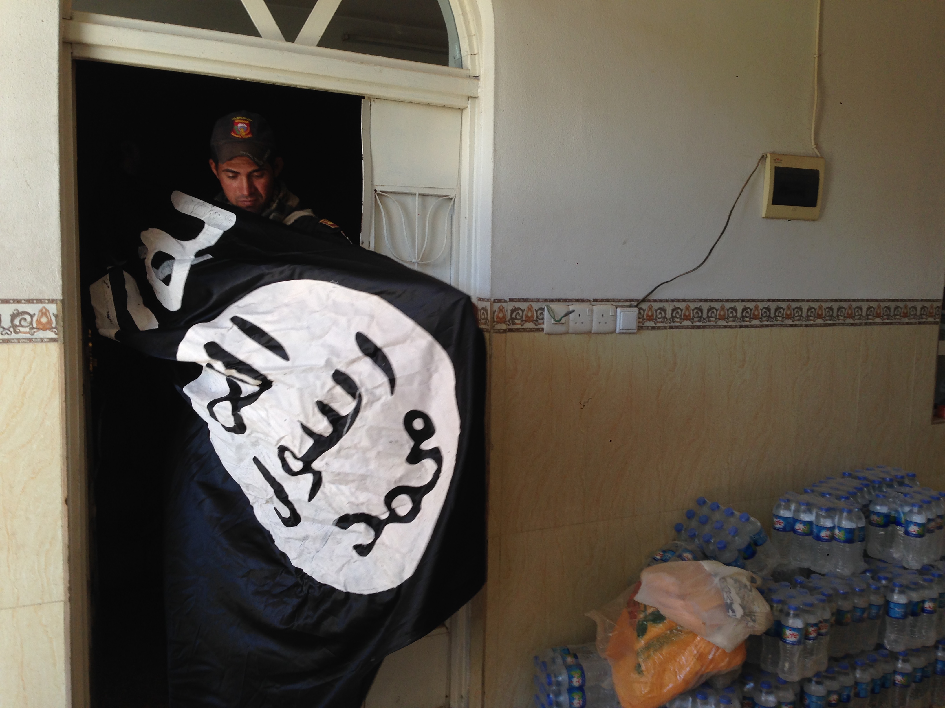 An Iraqi Special Forces soldier finds an IS flag in Mosul (MEE/Tom Westcott)