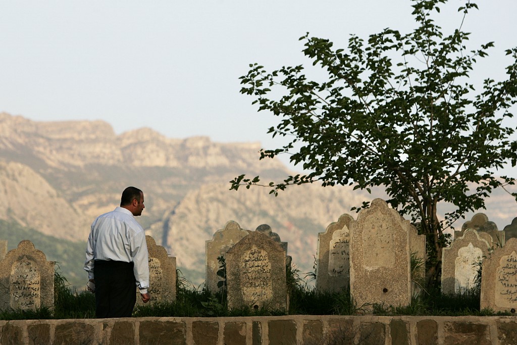 A Kurdish man examines gravestones at a monument to those killed during an Anfal attack in Sewsenan in 2006 (AFP)