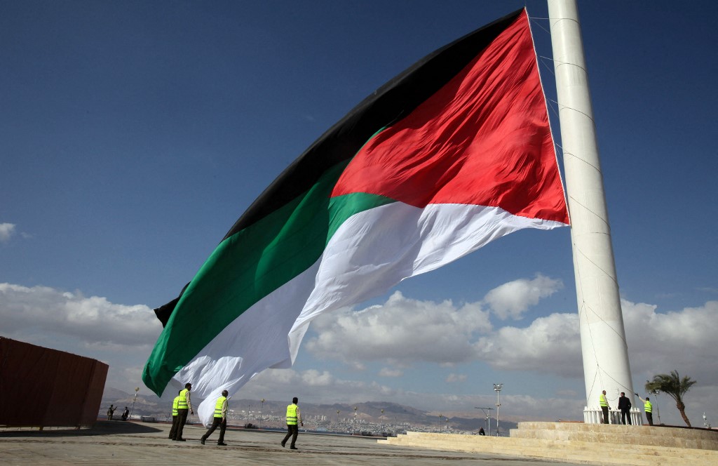 A giant Jordanian flag is raised during a celebration in the port of Aqaba in 2016 (AFP)
