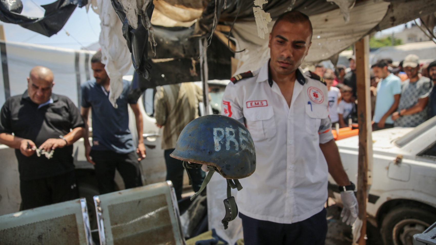 Rescuer Youssef al-Hindi holds the press helmet he found in the journalists's tent following the strike that killed Haydar Ibrahim al-Msaddar (Mohammed al-Hajjar/MEE)