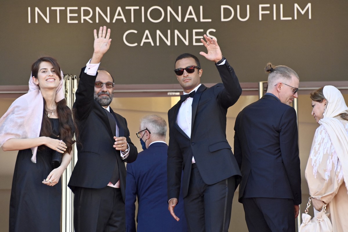 Iranian director Asghar Farhadi (2nd L) poses with his daughter Sarina (L) and Iranian actor Amir Jadidi (C) as they arrive for the screening of the film "Ghahreman"(A Hero) at the 74th edition of the Cannes Film Festival on 13 July 13, 2021 (AFP/John Macdougall)