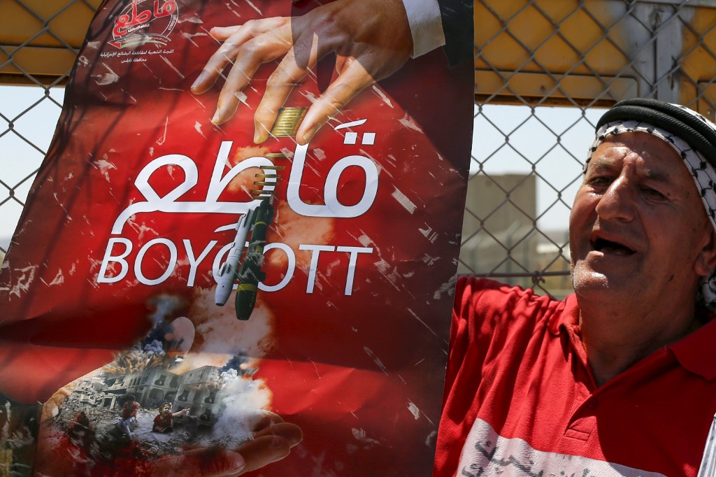 A Palestinian man demonstrates in support of BDS near Ramallah on 6 August (AFP)