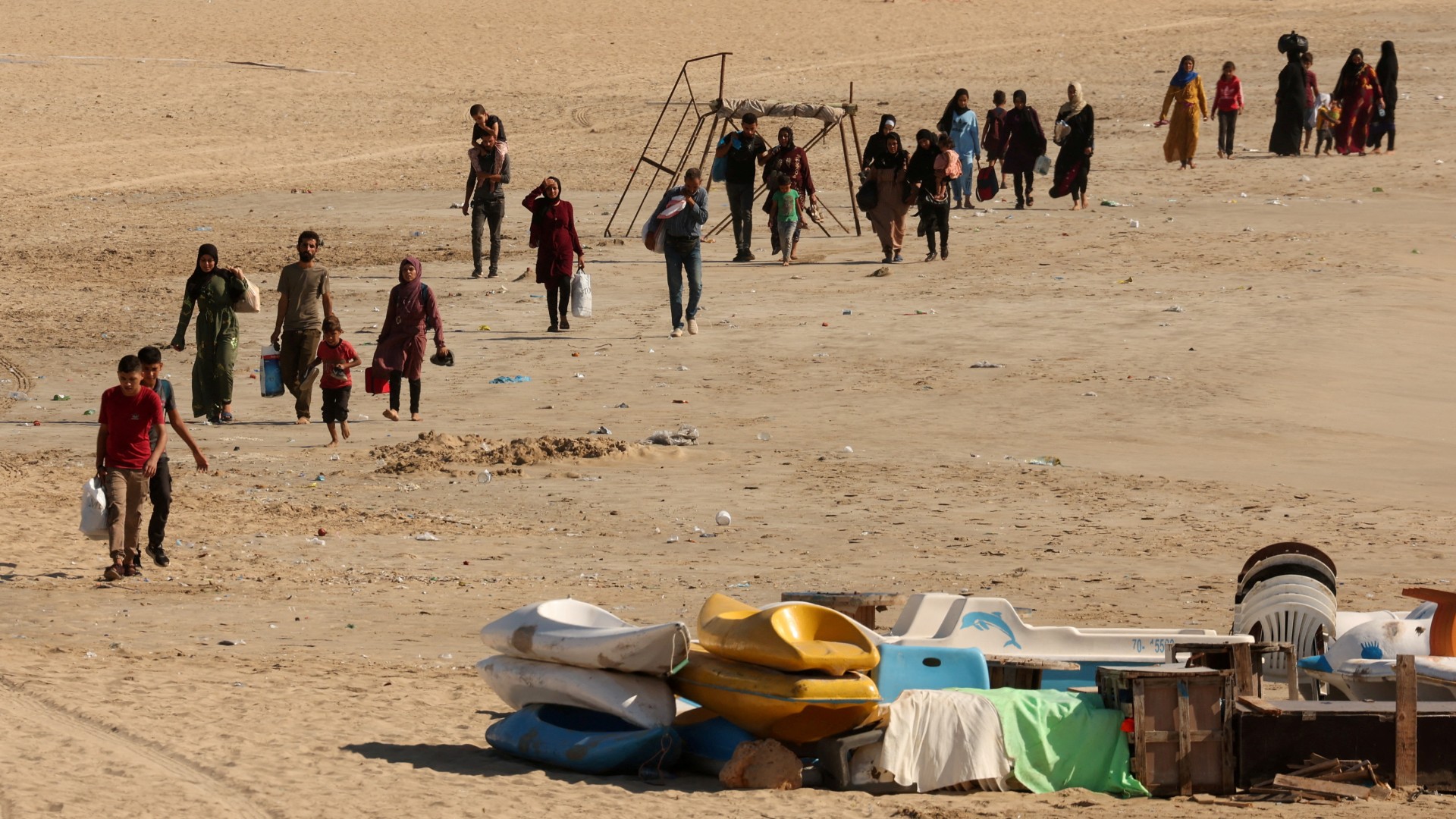 People carry belongings at a beach as they flee Israeli attacks in Tyre, southern Lebanon 23 September (Reuters/Aziz Taher)