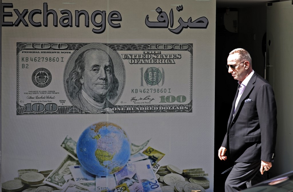 A man walks past a money exchange company in Beirut on 1 October (AFP)