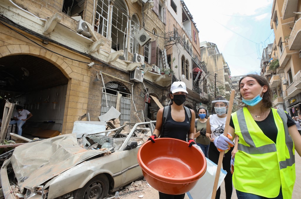 Volunteers arrive in Beirut’s Gemmayzeh neighbourhood to clear debris on 6 August (AFP)