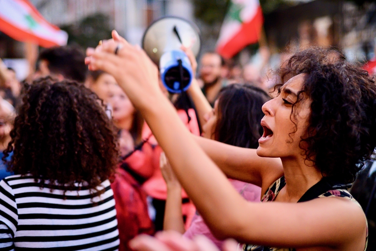 Woman in feminist march joins in chanting at edge of Martyrs’ Square in Beirut on Sunday night (MEE/Finbar Anderson)