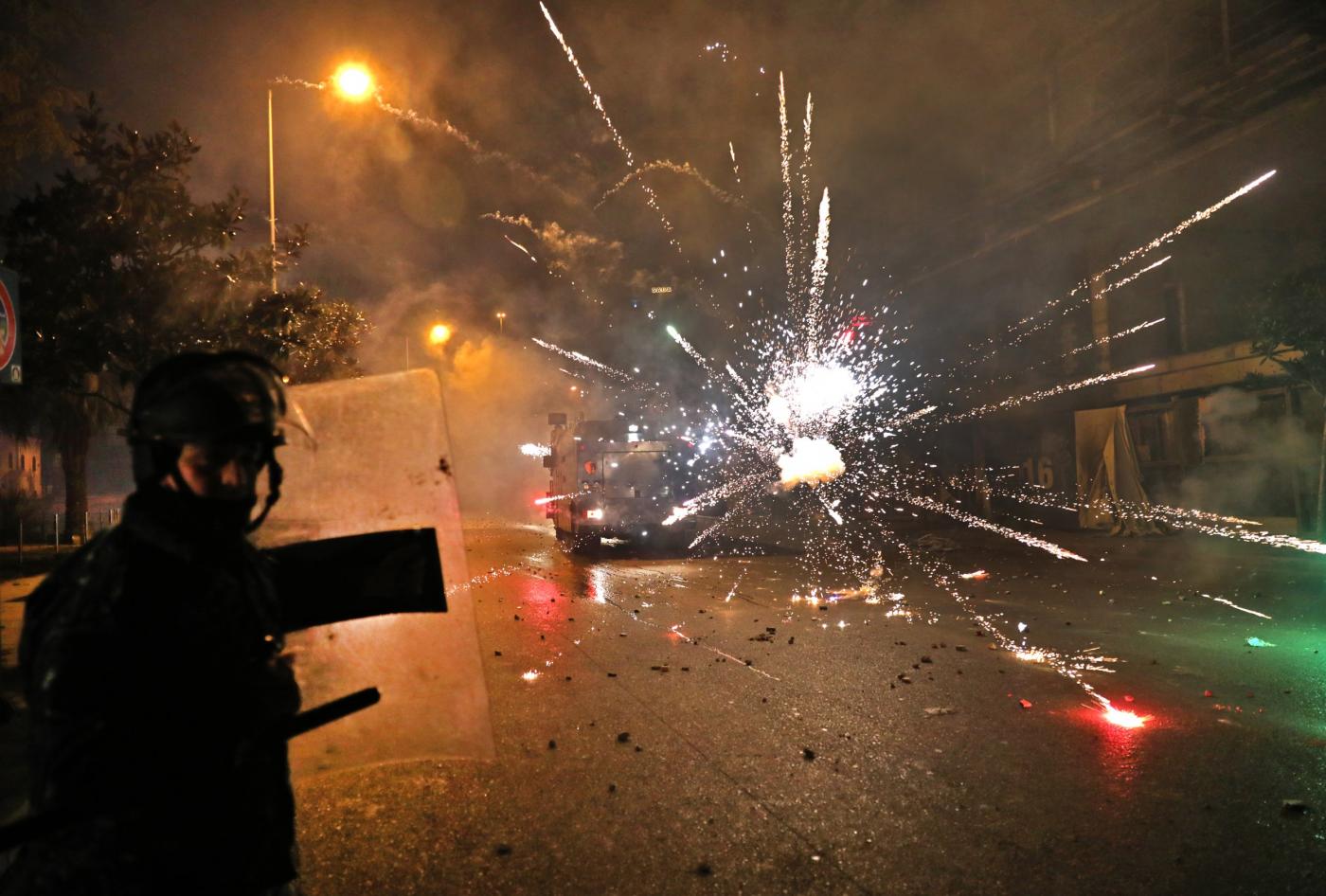 Des partisans du Hezbollah et d’Amal lancent des feux d’artifice sur les forces de sécurité dans le centre de Beyrouth, dans la nuit du 16 au 17 décembre (AFP)