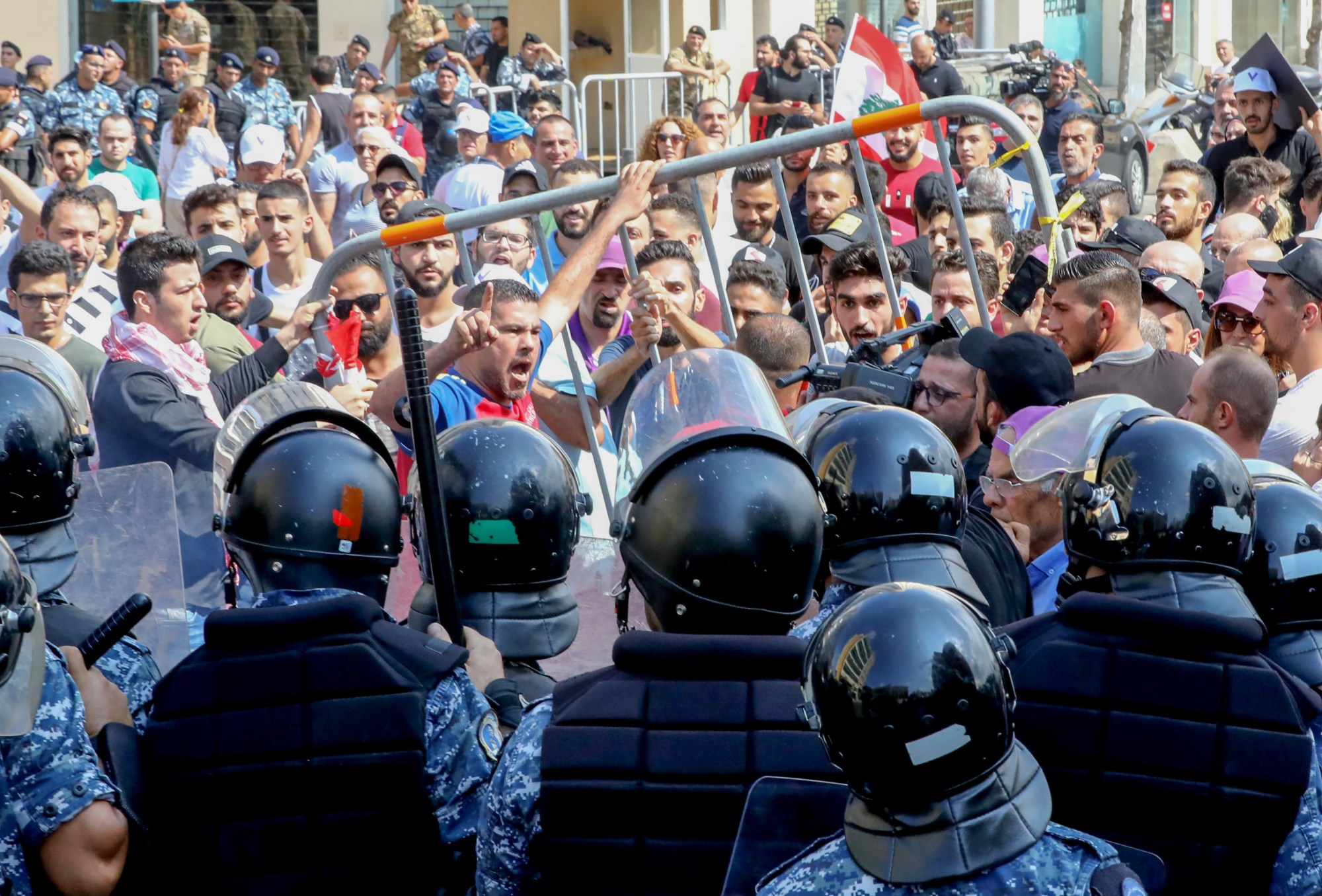 Lebanese protesters clash with riot policemen during a demonstration in central Beirut's Martyr Square on 29 September 2019 (AFP)