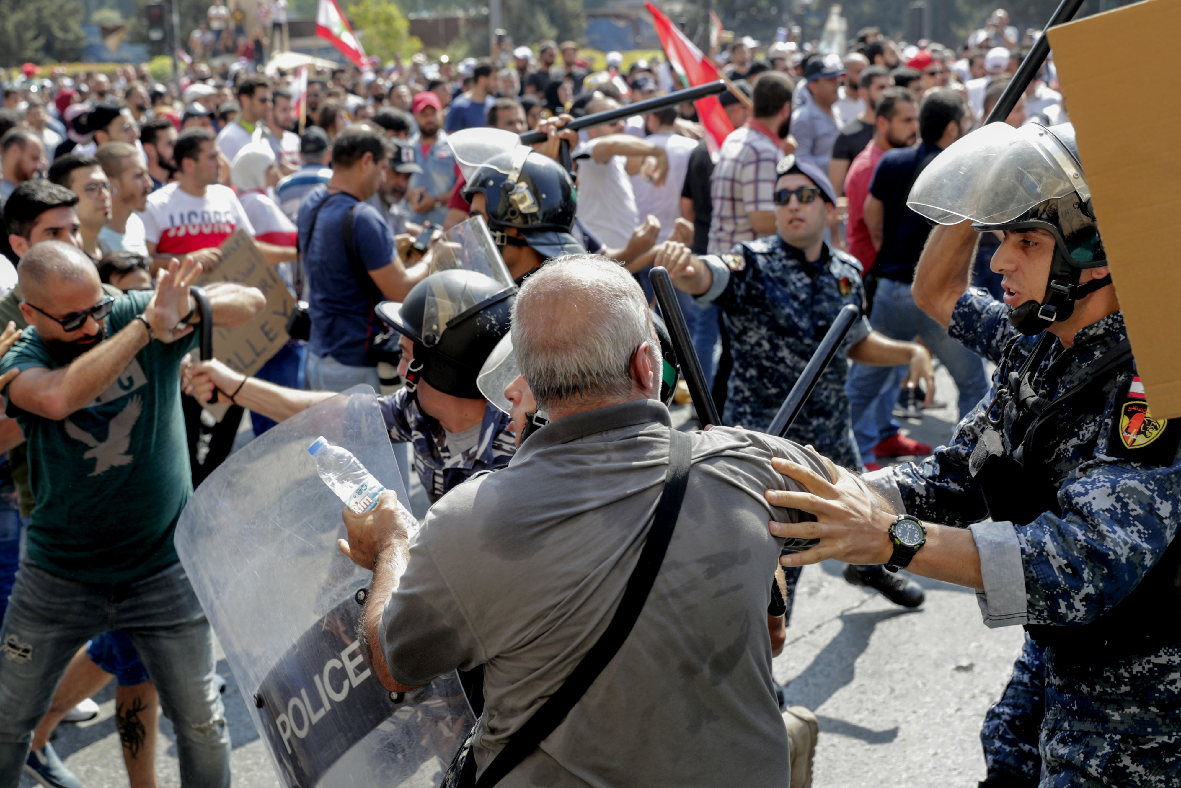 Lebanese protesters clash with riot policemen as they try to break through security barriers in front of the cabinet office during a demonstration in central Beirut's Martyr Square (AFP)