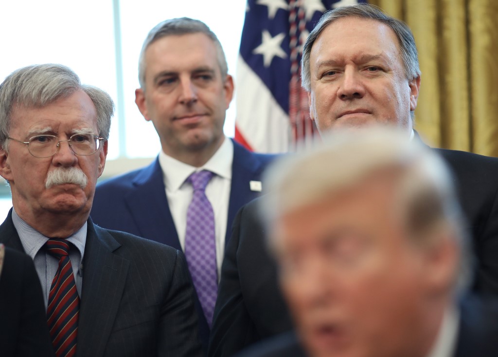 US National Security Adviser John Bolton and Secretary of State Mike Pompeo listen as Trump speaks in the Oval Office in Washington on 7 February (AFP)