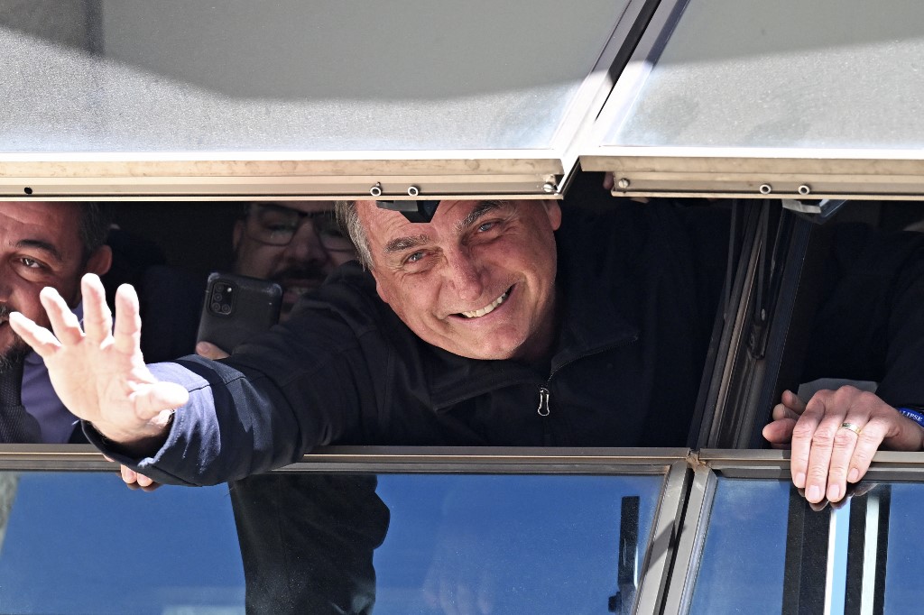Former Brazilian President Jair Bolsonaro greets supporters from a window at the Liberal Party headquarters in Brasilia on March 30, 2023. 