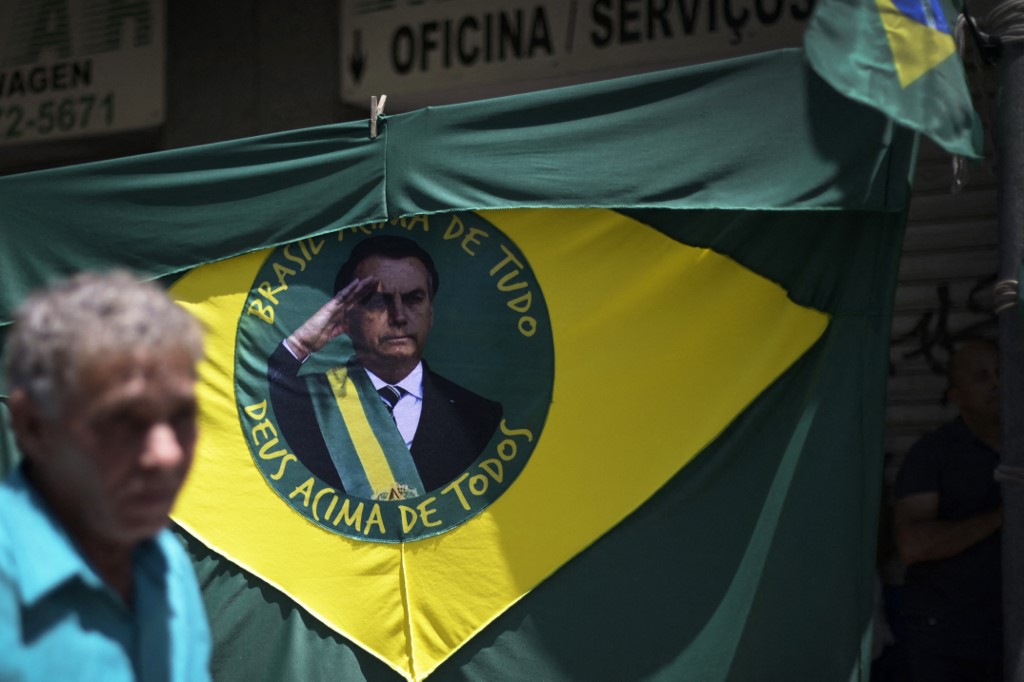 A Brazilian flag featuring a portrait of President Jair Bolsonaro hangs on a street in Belo Horizonte on 12 October 2022 (AFP)
