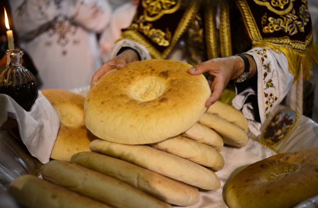 Le pain est distribué à la fin de l’office pour représenter le corps du Christ (AFP)