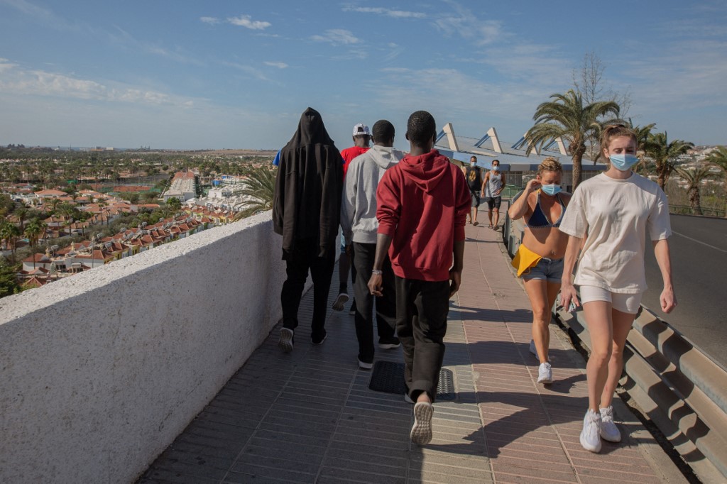 Malian migrants walk near their accommodation after being rescued by the Spanish coast guard in the Canary Island of Gran Canaria on November 23, 2020.