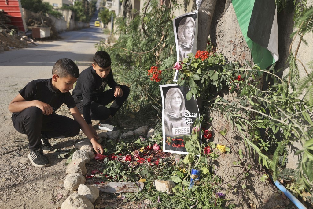 Children visit the site where Abu Akleh was shot dead in Jenin on 12 May 2022 (AFP)