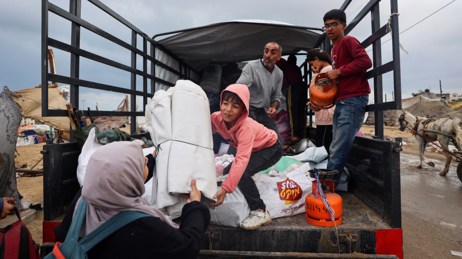 Palestinians load up a truck as they prepare to flee Rafah in the southern Gaza Strip on 13 May 2024 (AFP)