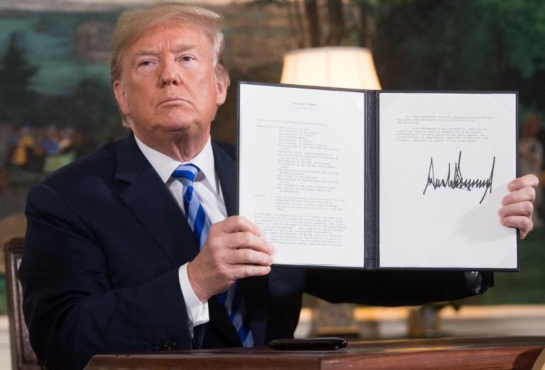 US President Donald Trump signs a document reinstating sanctions on Iran in May 2018 (AFP)