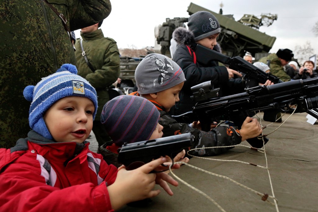 Children handle real unloaded guns and real unloaded rifles during a promotional campaign for contract service in the Russian Army, on December 20, 2014 in Sevastopol,
