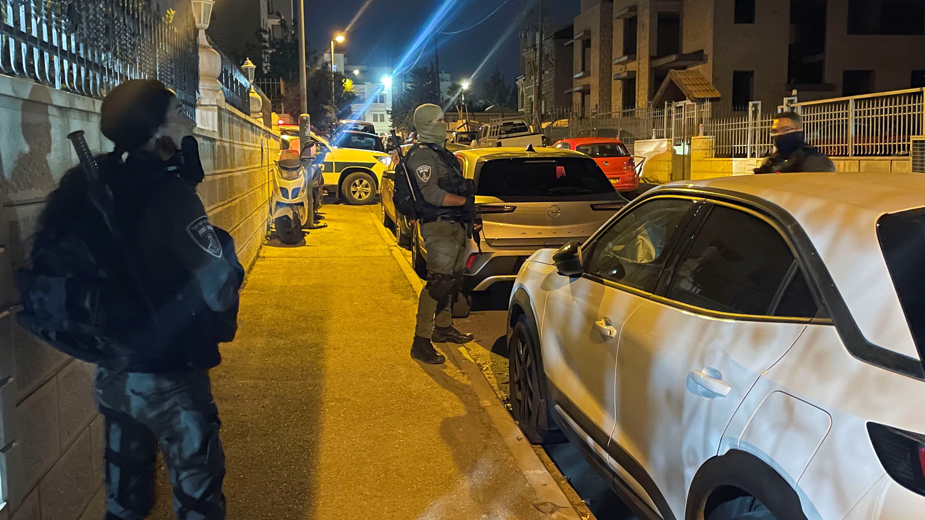 Israeli Policemen stand guard during a raid of a Palestinian prisoner's house who is set to be released today as part of a hostages-prisoners swap deal between Hamas and Israel 