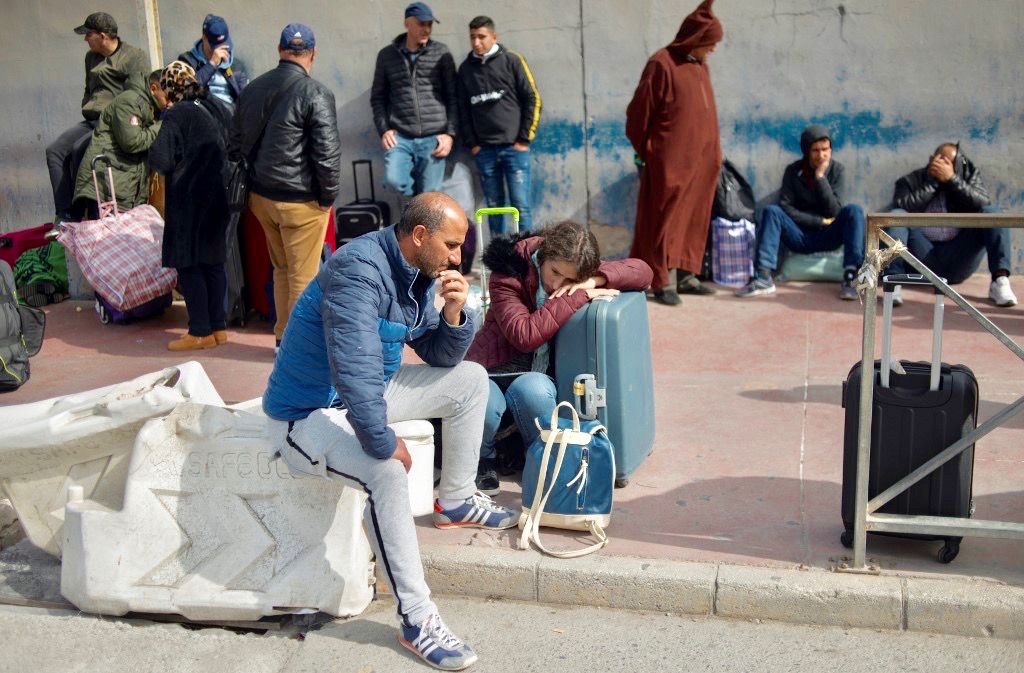 People wait to cross Spanish border with Morocco in Ceuta on 14 March (AFP)
