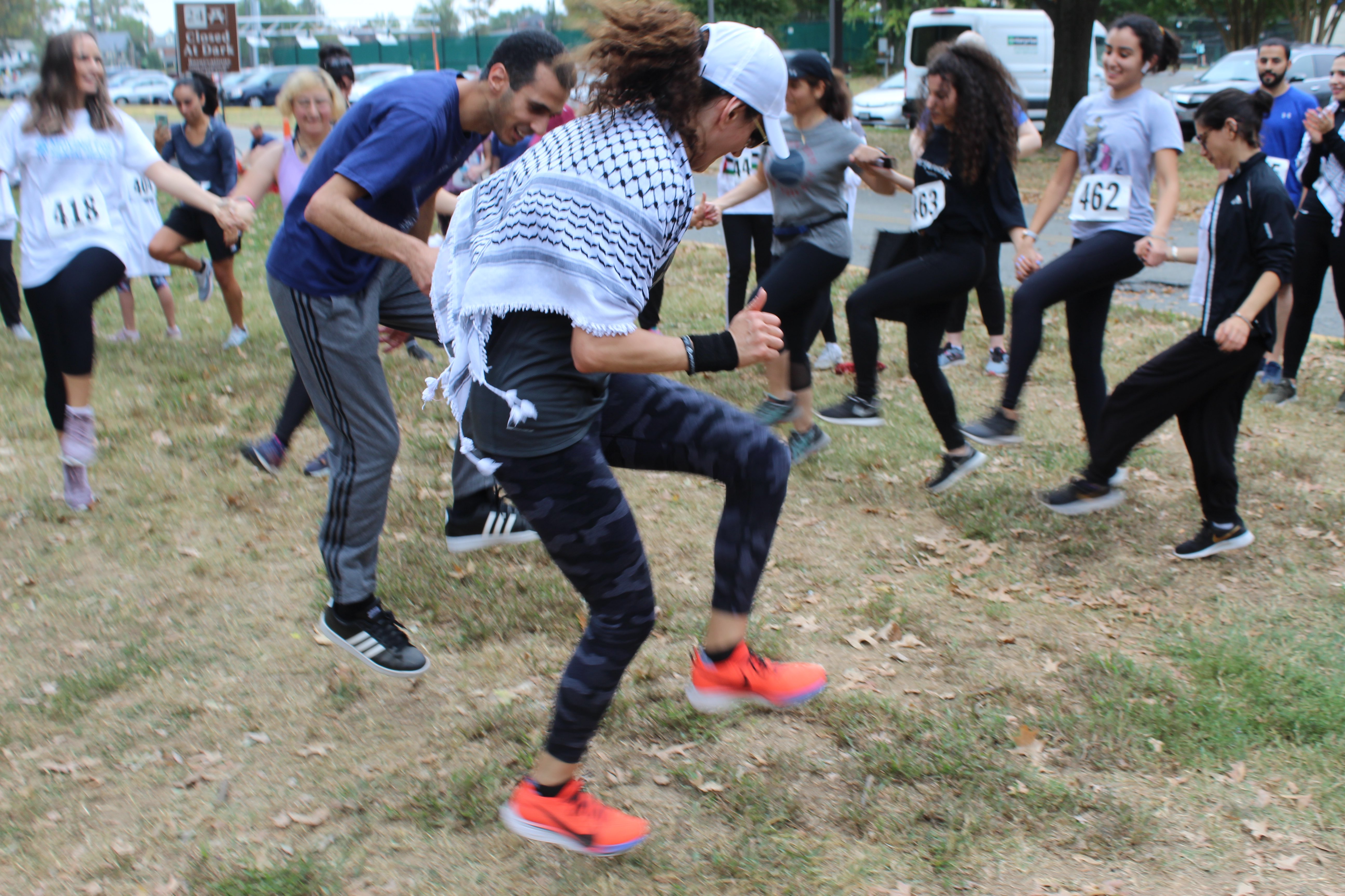 Two dancers take their dabka to another level after teaching beginners the basics at the Gaza 5k event (MEE/Sheren Khalel)