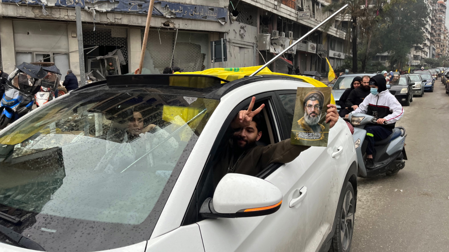 A man holds a picture of killed Hezbollah leader Sayyed Hassan Nasrallah while celebrating the ceasefire with Israel in Dahiyeh on 27 November 2024 (Nader Durgham/MEE)