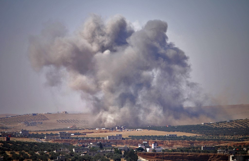 Smoke rises above the city of Daraa after regime air strikes in July 2018 (AFP)