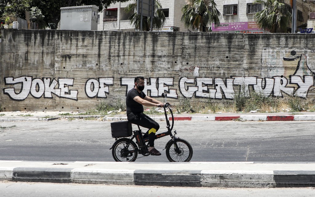 A mural in the occupied West Bank criticises the US ‘deal of the century’ on 2 July (AFP)