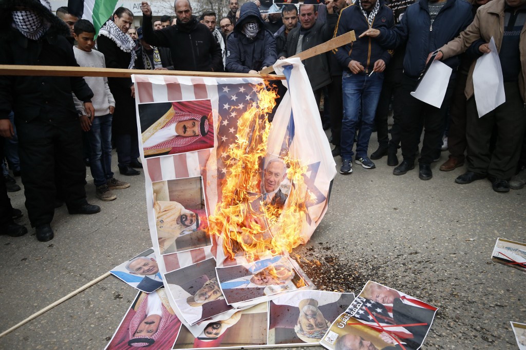 Palestinians set US and Israeli flags on fire to protest the Trump plan on 30 January (AFP)