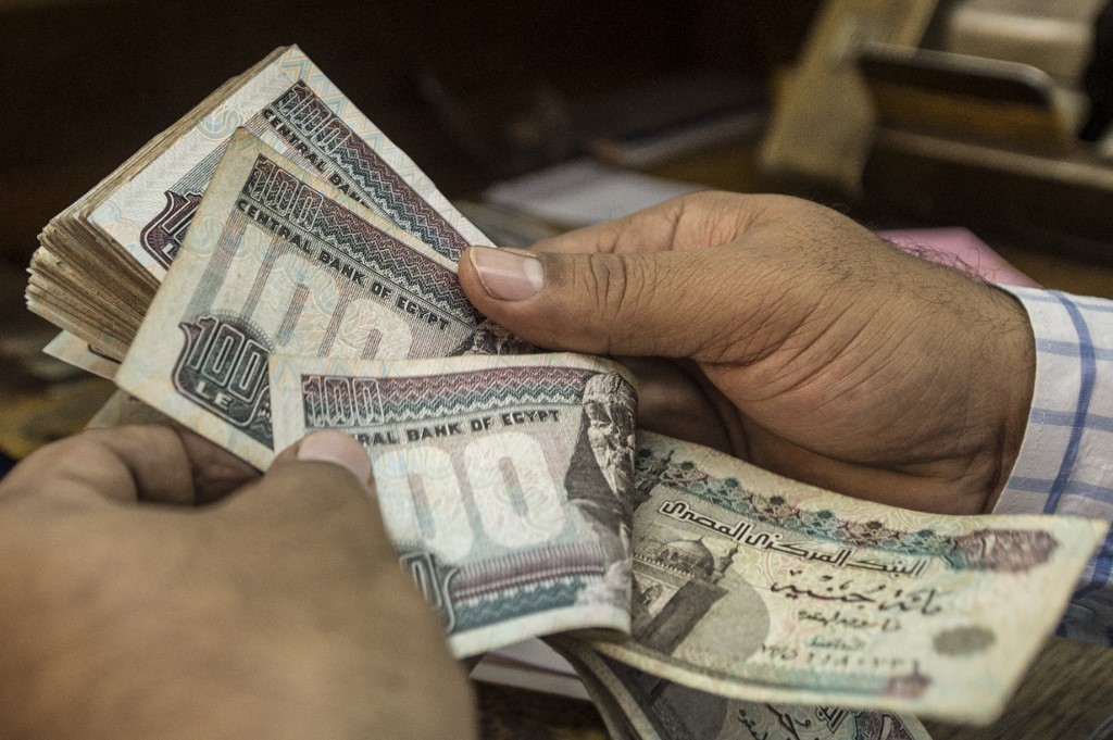 A man counts Egyptian pounds at currency exchange shop in Cairo. (AFP)