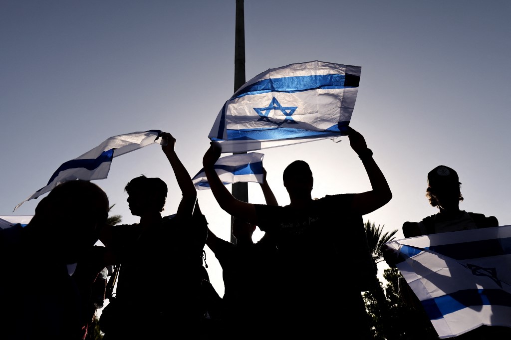 Far-right Israelis wave flags during a march in Jerusalem on 10 June 2021 (AFP)