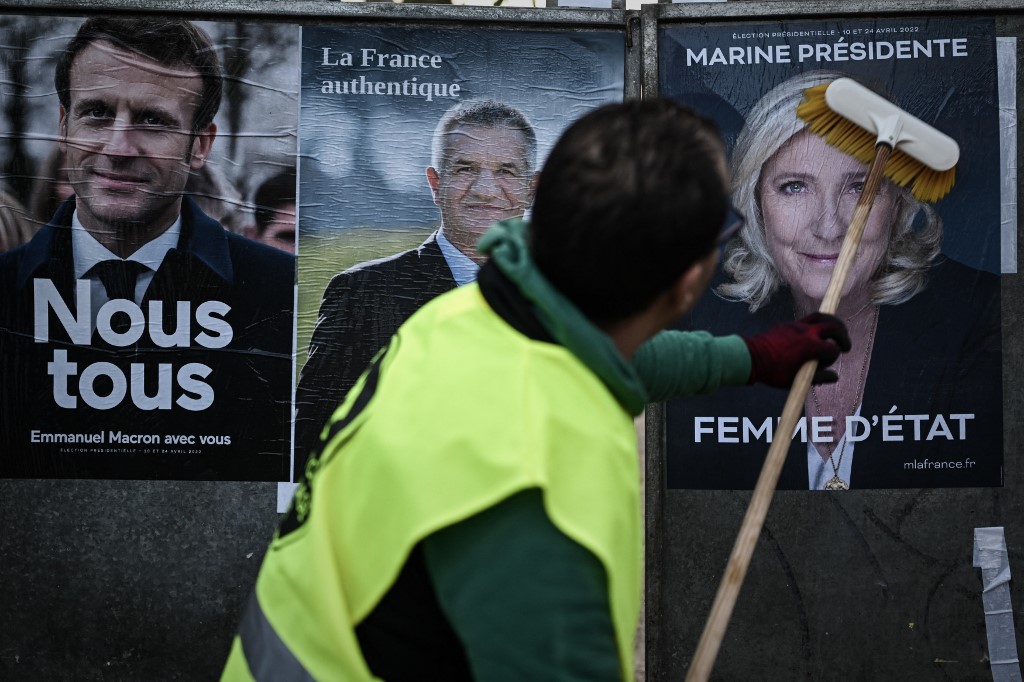 Campaign posters for President Emmanuel Macron and far-right candidate Marine Le Pen and MP Jean Lassalle are pictured in Bordeaux, southwestern France, on 28 March 2022 (AFP)